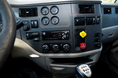 Peterbilt 579 cab interior dashboard showing gauges, climate controls, and gear shifter.