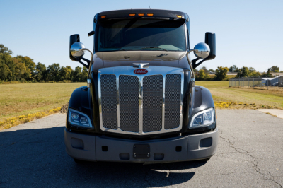 Peterbilt 579 conventional sleeper front view showing chrome grille, headlights, and bumper.