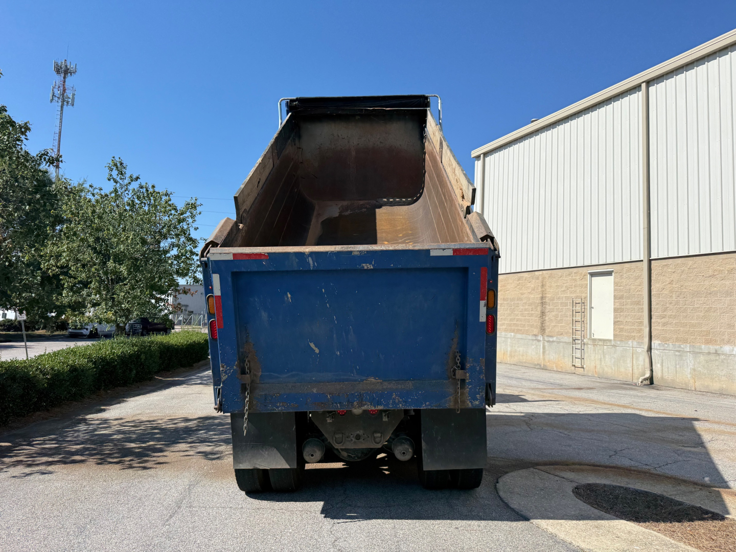 Dump truck bed on a Kenworth T880 rear view showing blue dump box and taillights.