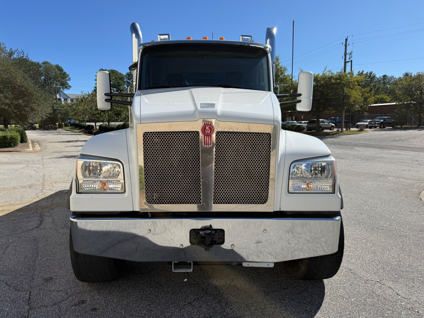 Front view of a white 2022 Kenworth T880 dump truck showing grille, headlights, bumper, and emblem.