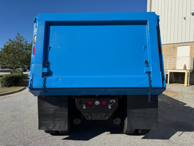 Dump truck bed of a 2022 Kenworth T880 showing rear gate and taillight area with blue dump body and black mud flaps.