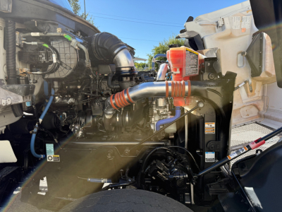 Kenworth T880 engine bay showing diesel engine components and intake piping.