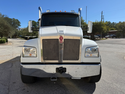 Front view of a white 2022 Kenworth T880 dump truck showing grille, headlights, bumper, and emblem.