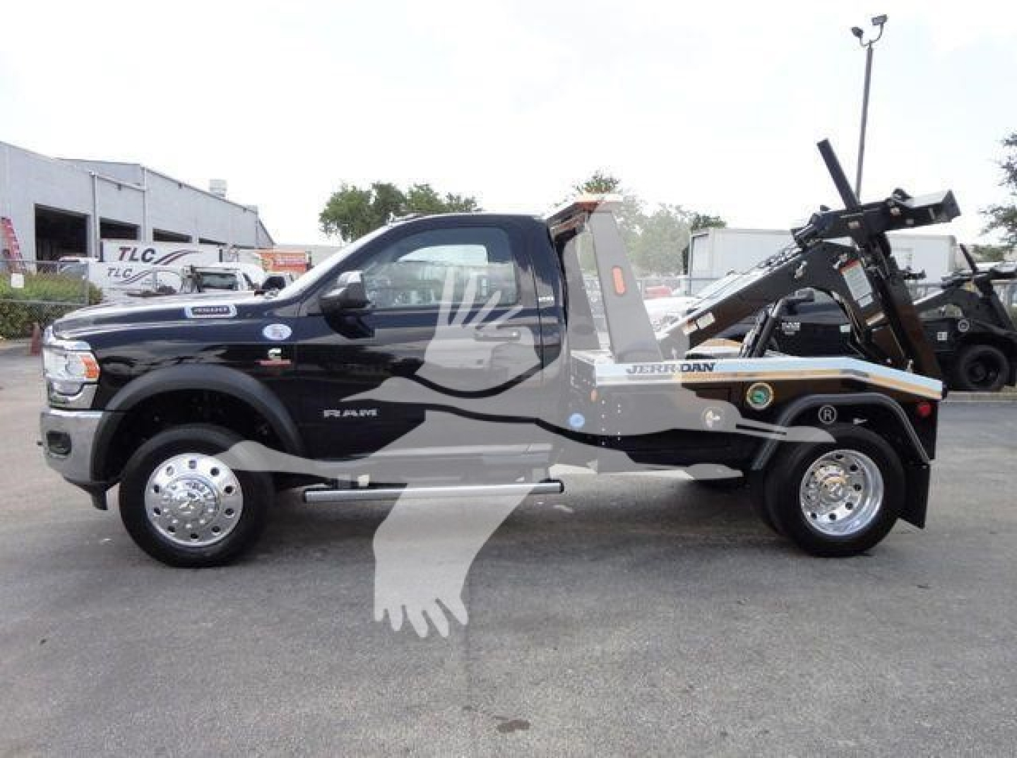 Ram 4500 rear-tilt tow truck side view showing black and gray wrap, 'RAM' badge, chrome wheels, winch apparatus in bed, stock number J68842.