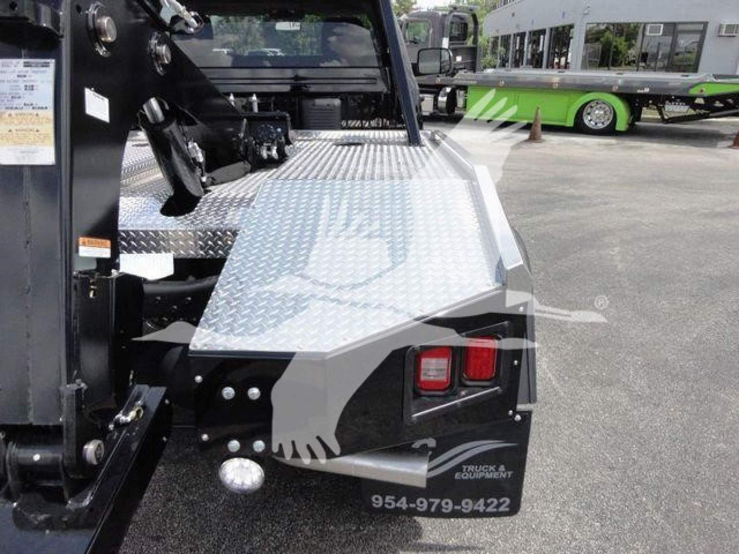 Ram 4500 HD SLT winch-equipped truck bed with diamond plate surface and rear lights. Visible contact number and logos on tailgate area.