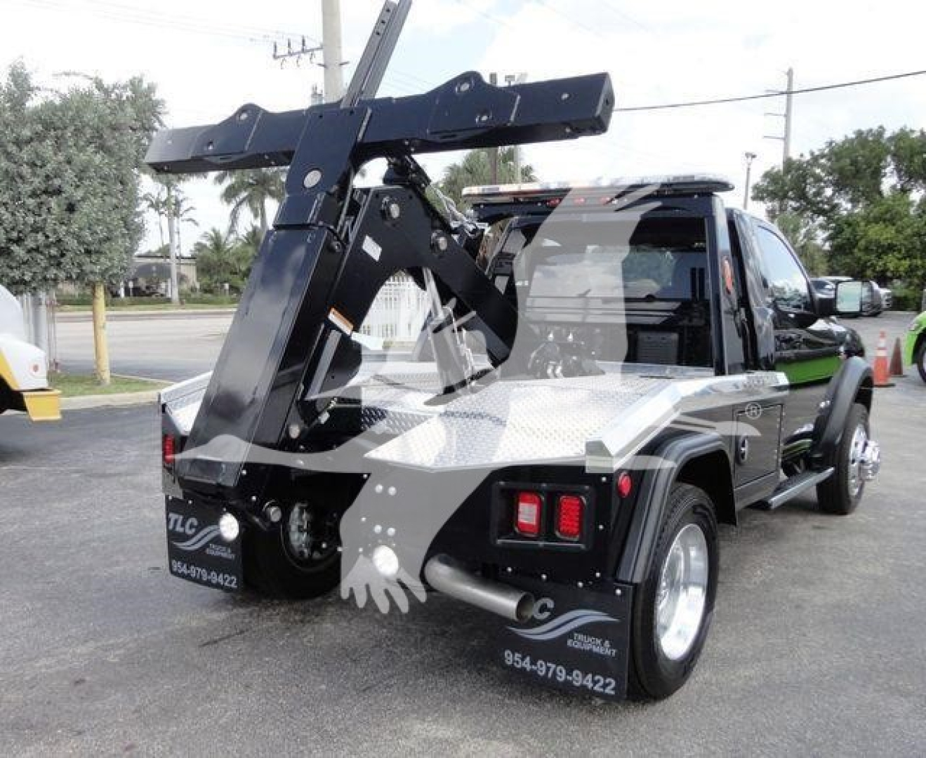 Ram 4500 HD SLT pickup truck with a large heavy-duty winch/loader crane mounted at rear, black paint, diamond plate bed, dual rear wheels, stock number J68842