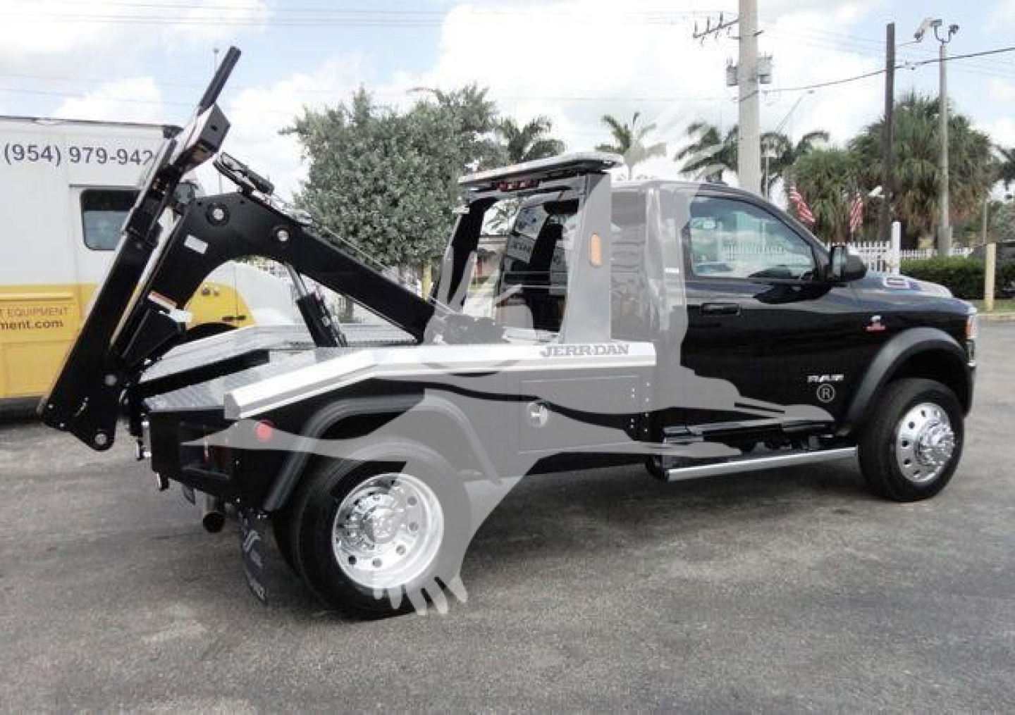 Ram 4500 HD SLT pickup with front winch system and mounted hydraulic lifting arm, side profile view, in-service black and gray wrap.