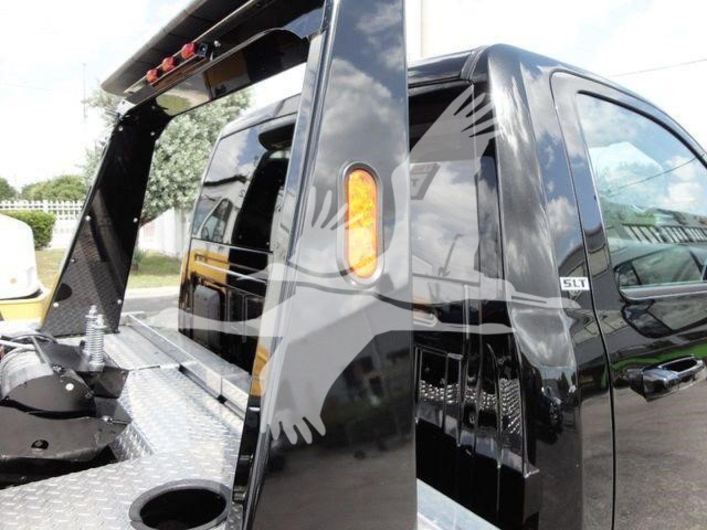 Ram 4500 HD SLT pickup with raised bed winch setup, steel diamond plate bed surface, and side view of cab window and SLT badge.