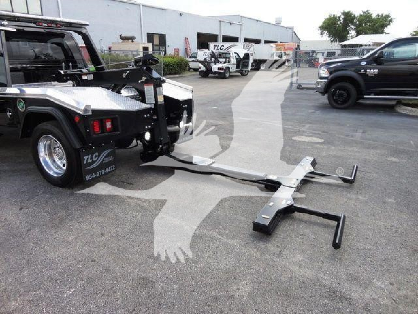 Ram 4500 truck with a mounted winch and tow hook setup in a dealership lot, showing the winch arm and hook components extending from the bed area.