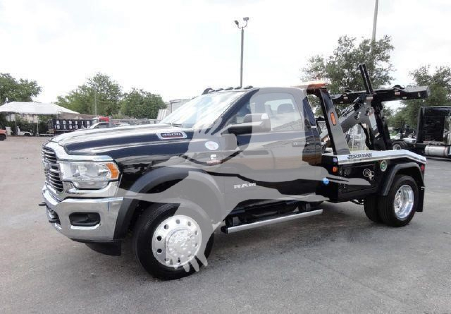 Ram 4500 pickup truck in service truck configuration with tow/winch equipment, showing Ram badges and wheel, side step, and black body with chrome grille.