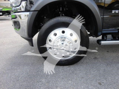 Truck wheel and front fender view showing a polished steel wheel and tire of a 2024 Ram 4500 HD SLT pickup in-service suspension components visible.