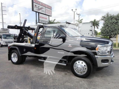 2024 Ram 4500 HD SLT tow truck with wheel-lift hoist and winch, black with chrome accents, side view showing bed and cab, stock number J68842