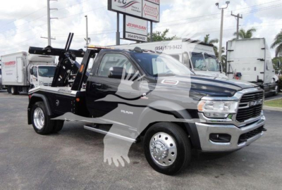 Ram 4500 heavy duty tow truck in black with chrome grille and winch setup, side view showing cab and wheel design.