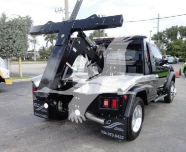 Ram 4500 HD SLT pickup truck with a large heavy-duty winch/loader crane mounted at rear, black paint, diamond plate bed, dual rear wheels, stock number J68842
