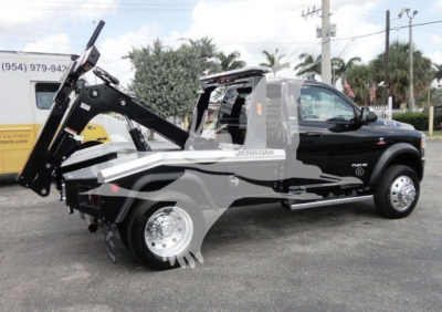 Ram 4500 HD SLT pickup with front winch system and mounted hydraulic lifting arm, side profile view, in-service black and gray wrap.