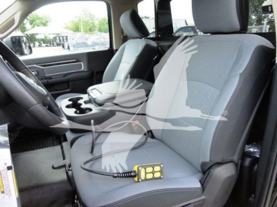 Ram 4500 cabin interior showing front seats and center console with a small yellow diagnostic device resting on the passenger seat.
