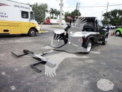 Ram 4500 pickup with winch setup and attached towing hitch in a dealership lot.