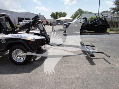 Ram 4500HD SLT truck with tow hitch and winch equipment attached, side view in dealership lot.