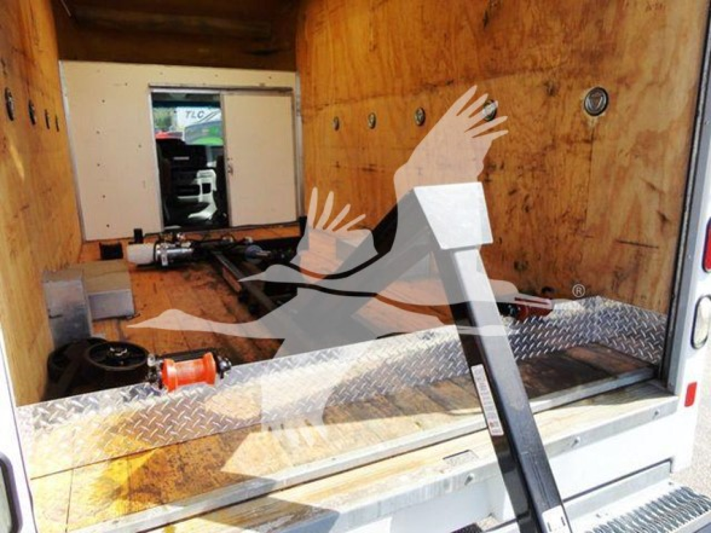 2015 Ford E350 Super Duty cutaway box truck cargo area with interior wood panels and diamond plate floor, rear doorway visible.