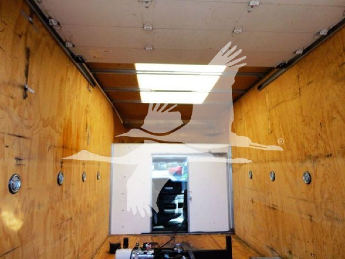 Ford E-350 cargo box interior with wooden walls and a small cab area visible at the far end.