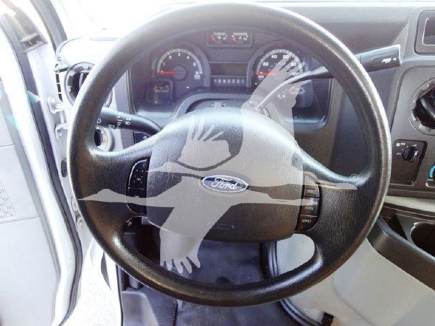 2015 Ford E350 Super Duty cutaway dash view showing steering wheel with Ford logo and instrument cluster.