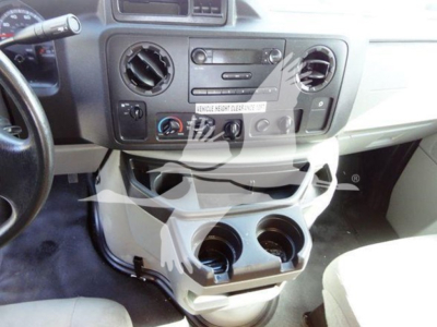 Ford E-Series van dashboard view with center console and cup holders showing two round cup slots and control panel.
