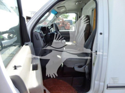Ford E-350 cutaway van interior cab view with front seat and steering wheel, side door open.