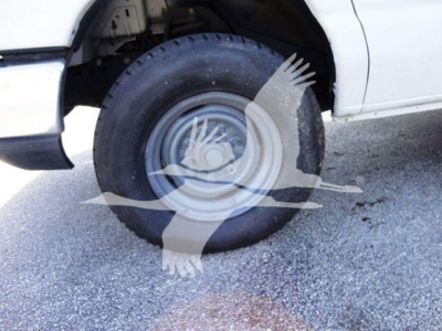 Ford E350 SD wheel and front fender view showing wheel, tire, and partial body with watermark overlay.