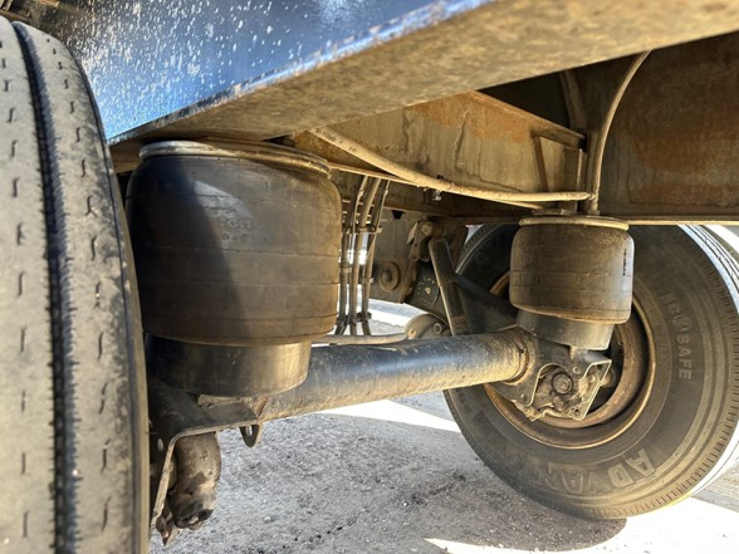 Trailer underside showing air suspension bags and axle with dual wheels on a utility spread air combo flatbed.