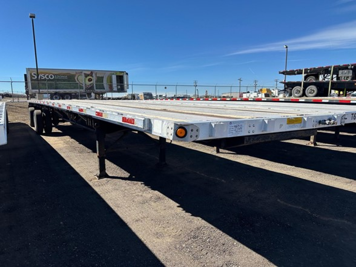 Utility spread air combo flatbed trailer showing long aluminum deck with support legs and reflectors.