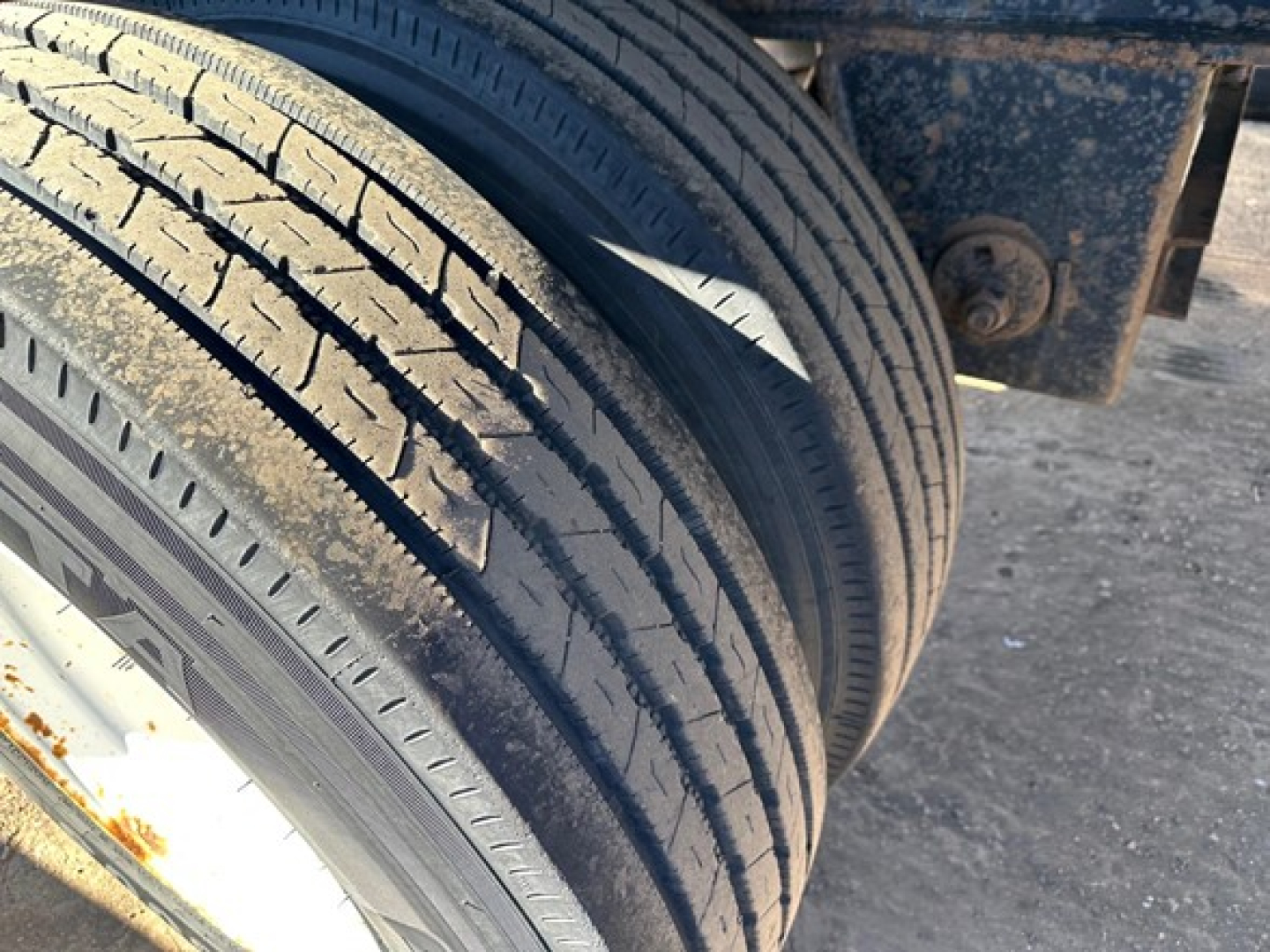 Dual rear tires of a utility spread air combo flatbed trailer showing tread and sidewall details.