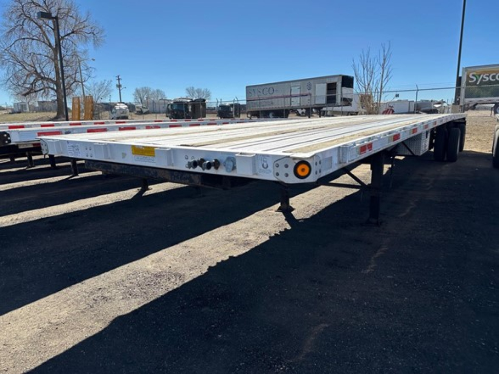Flatbed trailer showing low deck with extendable air spread? 2006 Utility Spread Air Combo Flatbed details not legible on the trailer; side markers and wheel area visible.