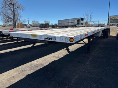 Flatbed trailer showing low deck with extendable air spread? 2006 Utility Spread Air Combo Flatbed details not legible on the trailer; side markers and wheel area visible.