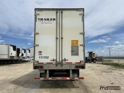 Rear view of a white 53' dry van semi trailer showing doors, latches, and safety stickers, with 'TRAILER' text and registration number visible.