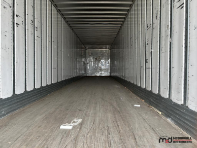 Trailer interior showing empty 53' dry van with metal walls and wooden floor, dim lighting in the cargo area.