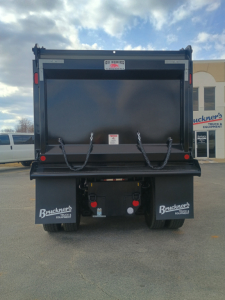 Mack GR84F dump truck bed showing rear view with chains and taillights