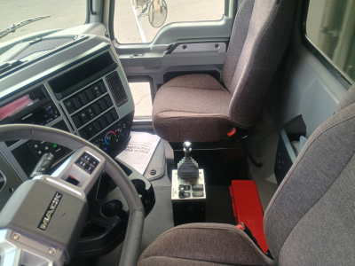 Cab interior of 2026 Mack GR84F dump truck showing steering wheel, driver seat, center console with gear shifter, and dashboard instruments.