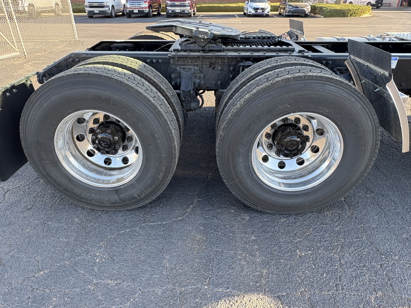 AN64T Mack truck rear axle with dual tires and chrome wheels, chassis frame visible, no cab portion in view.
