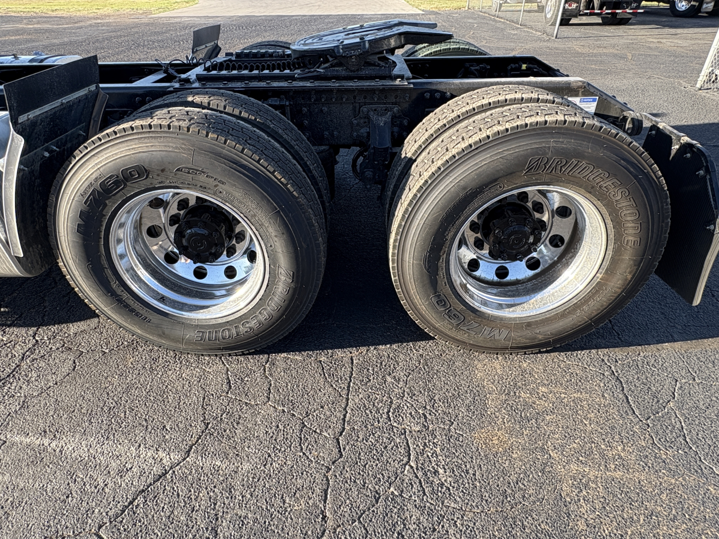 Dual rear trailer tires on a Mack AN64T tractor showing wheel rims and tires with tread, undercarriage and frame.
