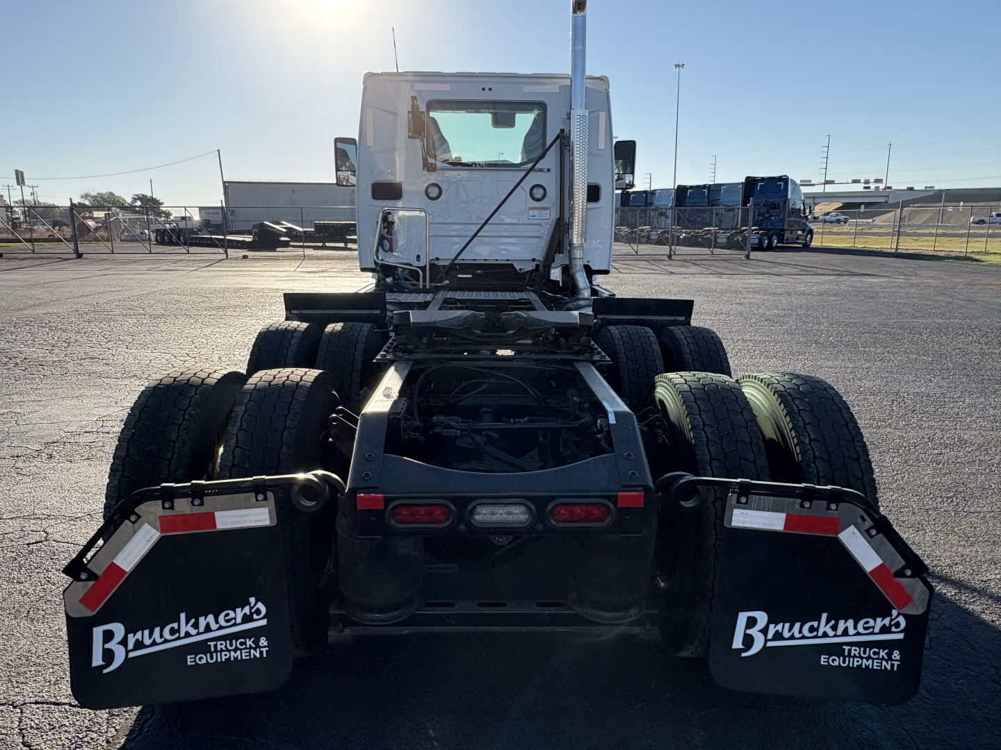 Mack AN64T conventional daycab rear view showing dual rear axles, mud flaps with Bruckner's Truck & Equipment branding, and chassis frame.