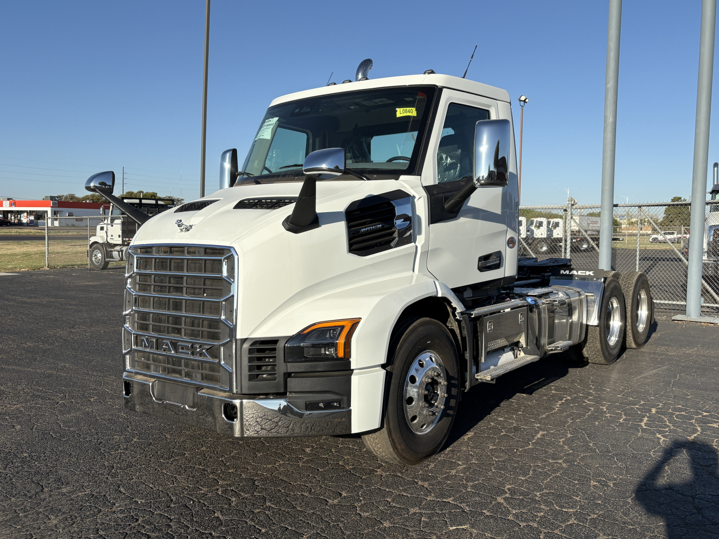 Truck cab and chassis showing Mack AN64T branding on grille and chrome exhaust area.