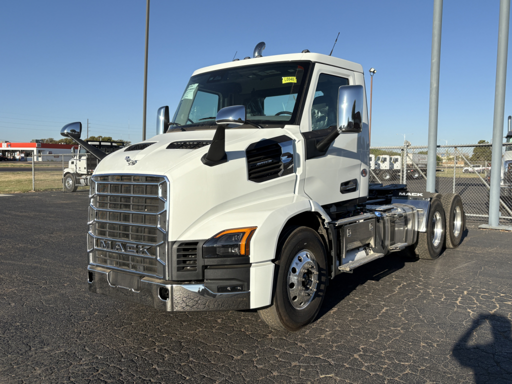 Truck cab and chassis showing Mack AN64T branding on grille and chrome exhaust area.