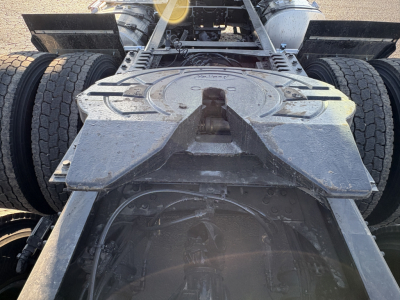 Truck chassis with fifth wheel and dual rear axle showing mounting platform and suspension; viewed from rear, Mack AN64T cabless? frame and wheel setup visible.