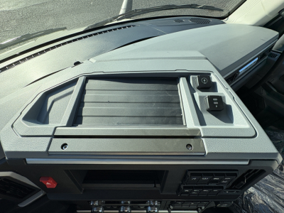 Dashboard center panel of a Mack AN64T truck cab showing storage tray and control switches.