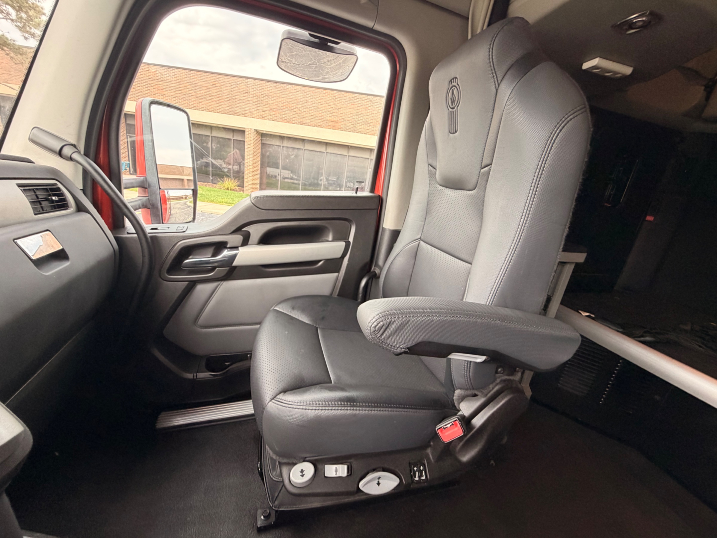 Truck cab interior showing driver's seat and door panel of a Kenworth T680