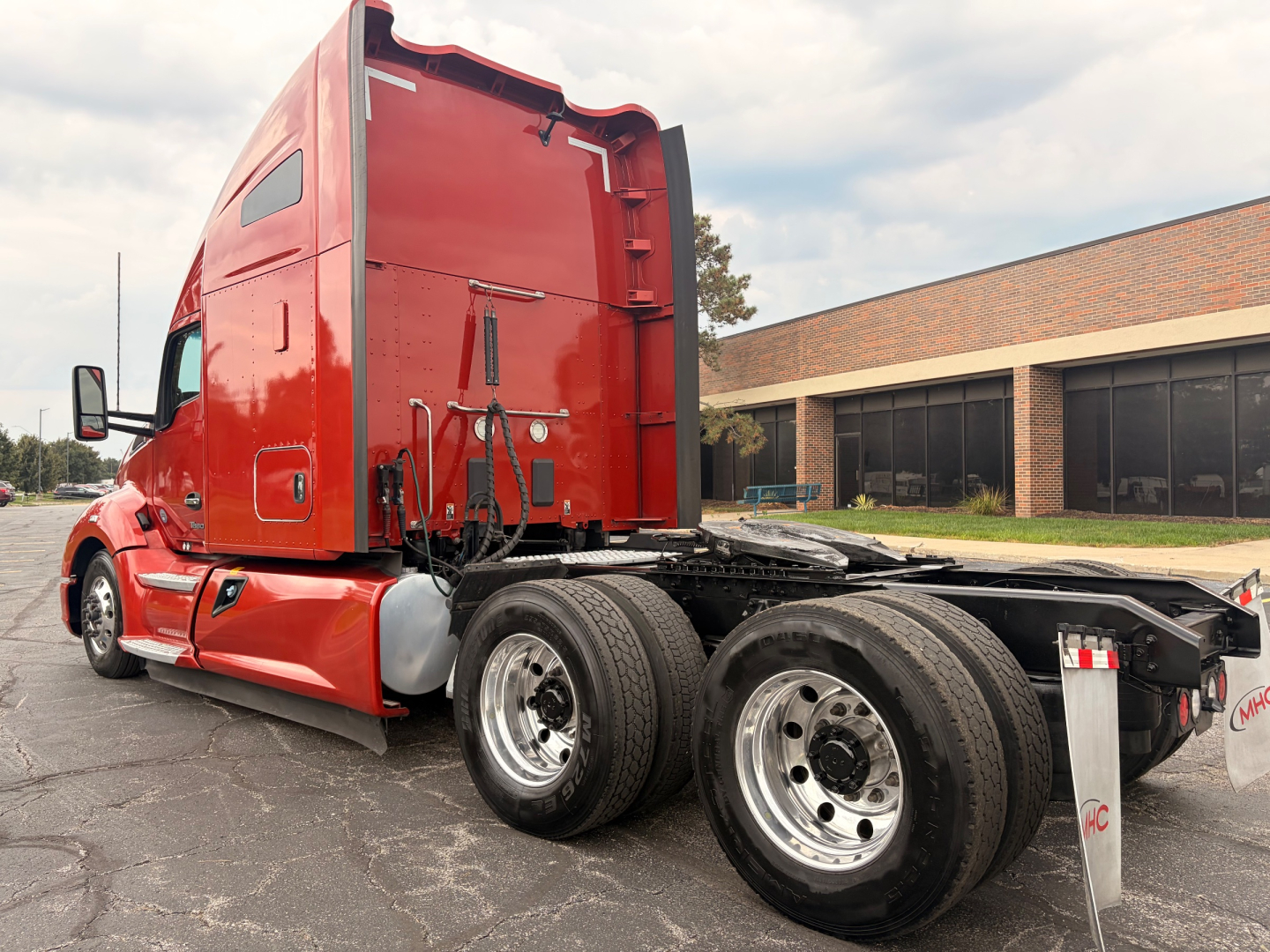 Kenworth T680 6x4 tractor in red, exterior side view showing sleeper cab, chassis with dual rear axles and fifth wheel, no load tags visible.