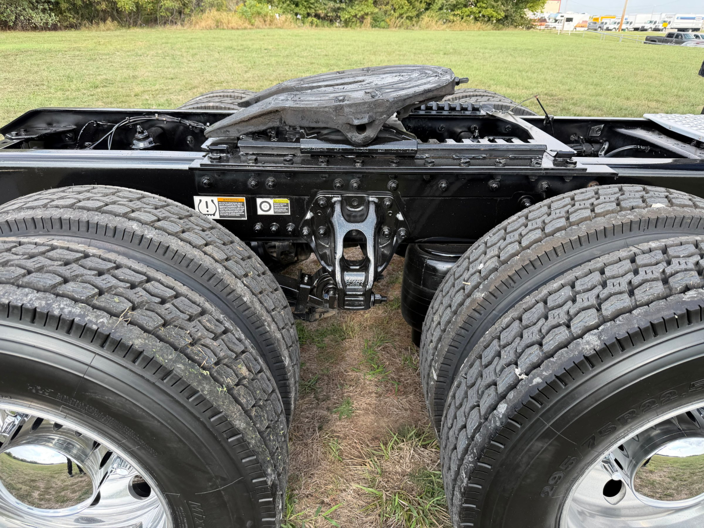 Kenworth T680 chassis showing dual rear axles and suspension components from the cab-to-axle area.