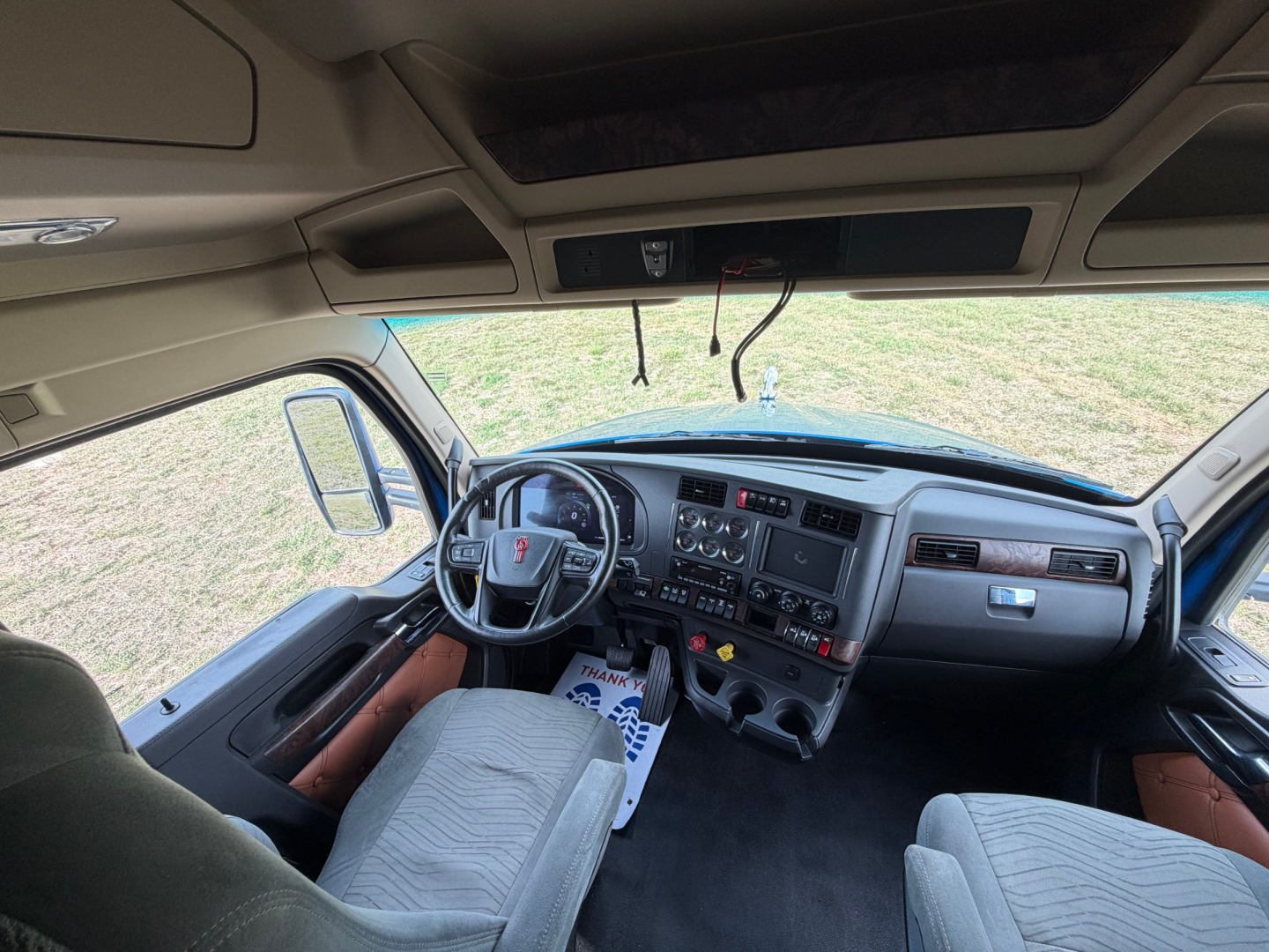 Kenworth T680 truck interior view of cab, steering wheel, dashboard, and driver seat.