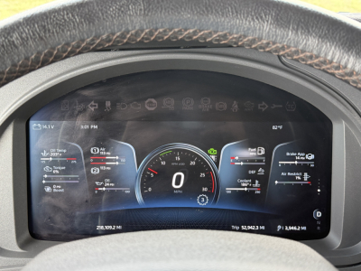 Kenworth T680 dash cluster digital display showing speedometer at 0 mph, gauges and indicators, steering wheel visible.