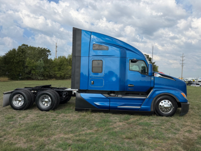 Kenworth T680 tractor cab side view showing blue exterior and wheel configuration.